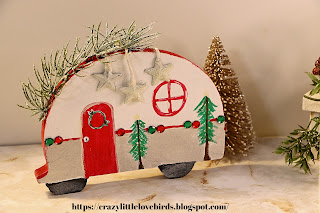 Decorative winter camper with greenery, paint, and gems